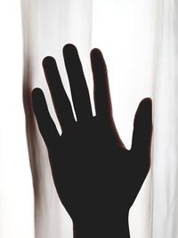 Close-up of silhouette hand against wall