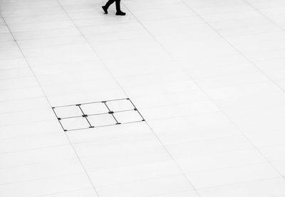 Low section of person walking on tiled floor