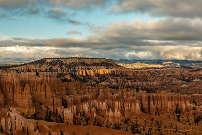 Panoramic view of rocky mountains against cloudy sky