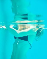 Midsection of young woman swimming in pool