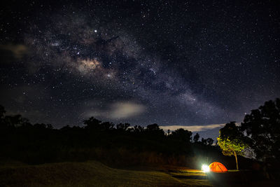 Illuminated tent on land against sky at night