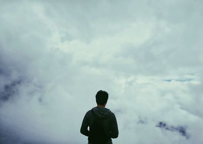 Rear view of silhouette boy standing against sky