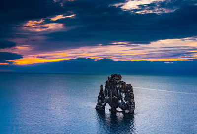 Scenic view of sea against cloudy sky during sunset