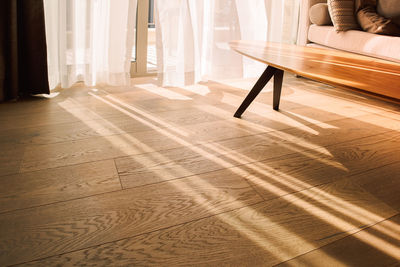 Modern room interior with an open window in minimal style. transparent tulle with morning sun rays 