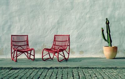 Empty chairs and table against wall