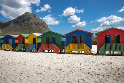 Panoramic view of beach huts by buildings against sky