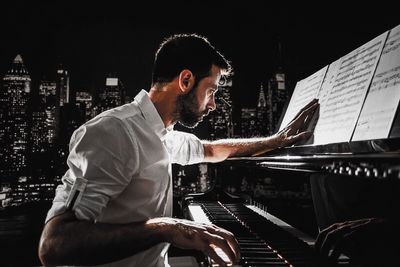 Side view of young man looking up at night
