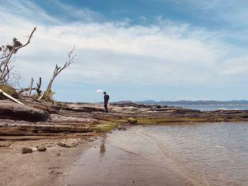 Rear view of man on beach against sky