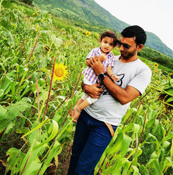 Full length of father and son on land
