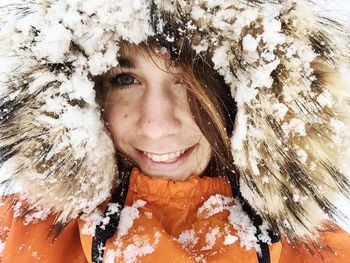 Close-up of happy woman with snow on fake fur