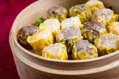 Close-up of dim sums in bamboo steamer on table