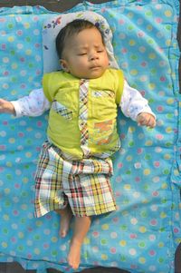 High angle view of baby girl lying on bed