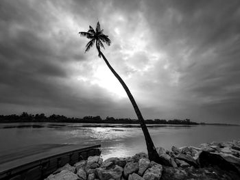 Silhouette rocks by sea against sky