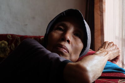 Portrait of woman lying on sofa at home