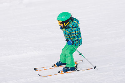 Full length of boy skiing on snow covered land