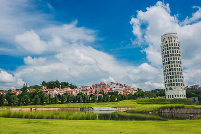 Buildings in city against cloudy sky