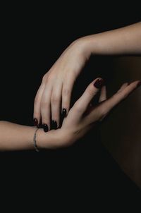Cropped hand of person against black background