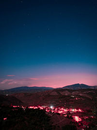 Scenic view of illuminated mountains against sky at night