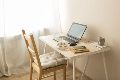 Table and chairs on bed against wall at home