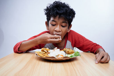 Portrait of woman eating food on table