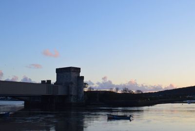 Boats in river at sunset