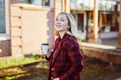 Portrait of young woman holding drink