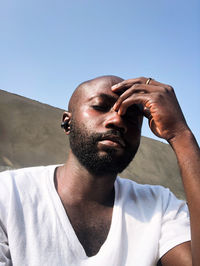 Young man looking away against clear sky