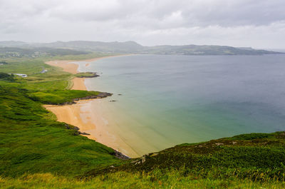 Scenic view of beach and sea against cloudy sky