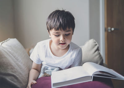 Boy looking at book at home