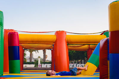 Rear view of people lying on multi colored against clear sky