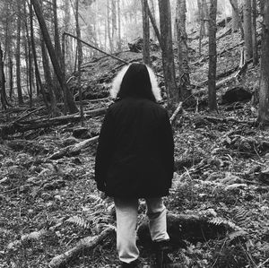 Rear view of woman standing in forest