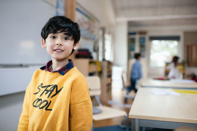 Portrait of boy standing in classroom