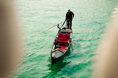 Rear view of men on boat in river