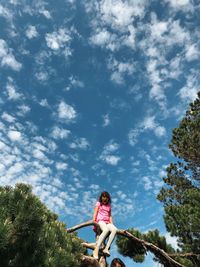 Low angle view of woman standing against sky