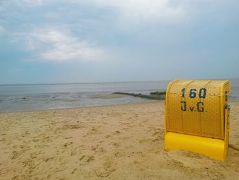 Scenic view of beach against cloudy sky