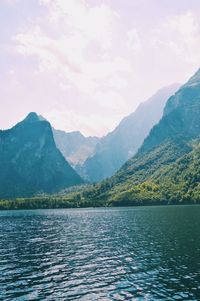 Scenic view of lake by mountains against sky