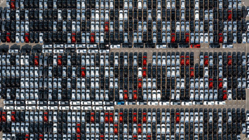 Aerial top view rows of new cars parked in distribution center on car factory.