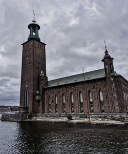 Tower of building against cloudy sky