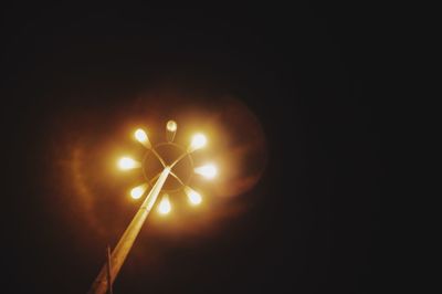 Low angle view of illuminated lamp post at night