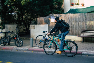 Side view of man riding bicycle on street