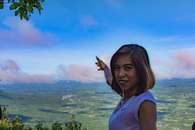 Portrait of smiling woman on landscape against sky