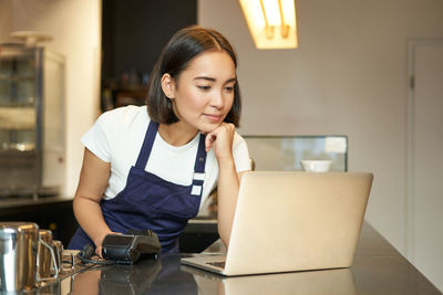 Young woman using laptop while sitting at home