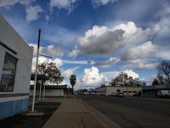 Road amidst buildings in city against sky