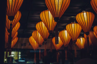 Low angle view of illuminated lanterns hanging from ceiling at night