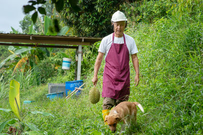 Full length portrait of man holding dog in park