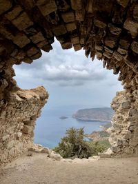 Rock formations by sea against sky