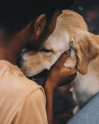 Close-up of man embracing with dog outdoors