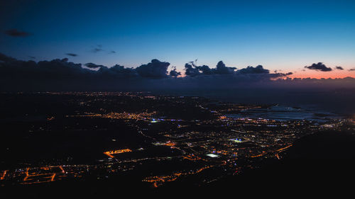 Aerial view of illuminated city at sunset