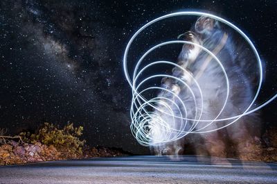 Digital composite image of light painting against sky at night