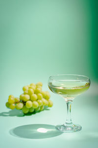 Grapes and wine against green background